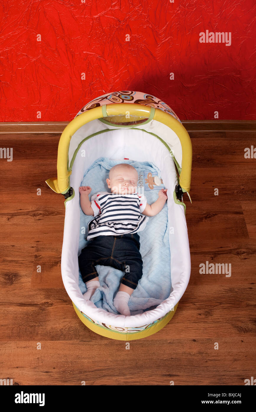 Two months old cute baby girl sleeping comfortably in a stroller in the