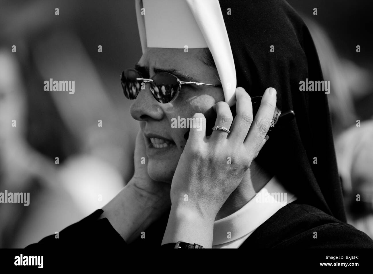 A Czech nun having a call during the open-air mass served by the Pope Benedict XVI in Stara Boleslav, Czech Republic. Stock Photo