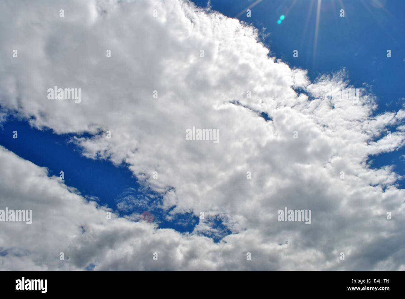 sun against the blue sky with white clouds Stock Photo - Alamy
