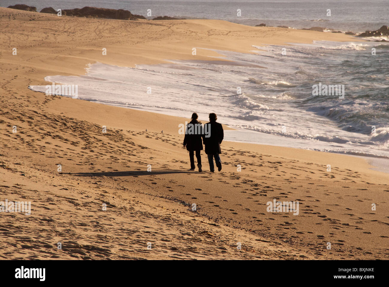 A couple taking the proverbial 'long walk on the beach'. Vila do Conde, Portugal Stock Photo