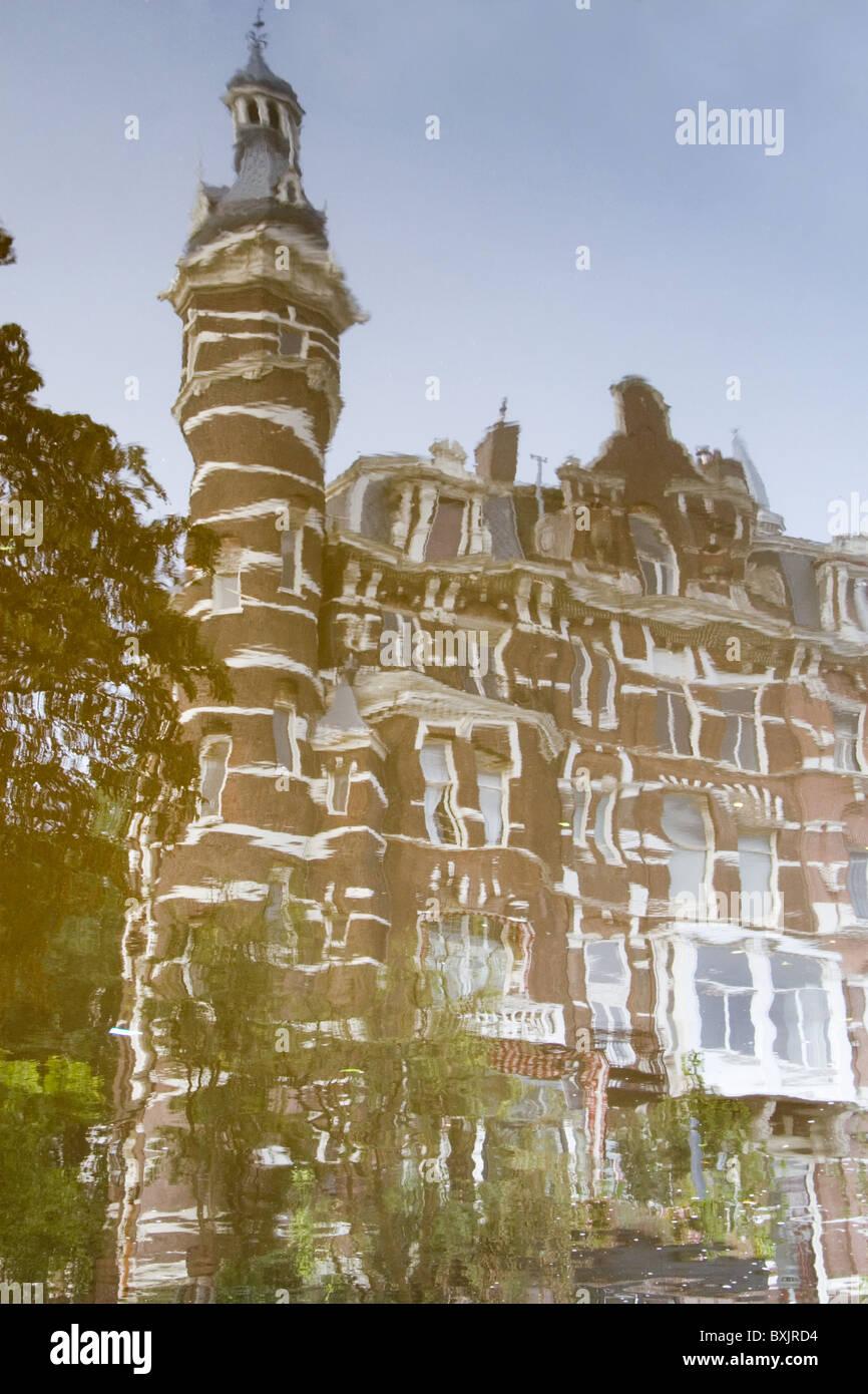 Distorted reflection of a Dutch towered building in canal waters: Amsterdam September 2010 Stock Photo