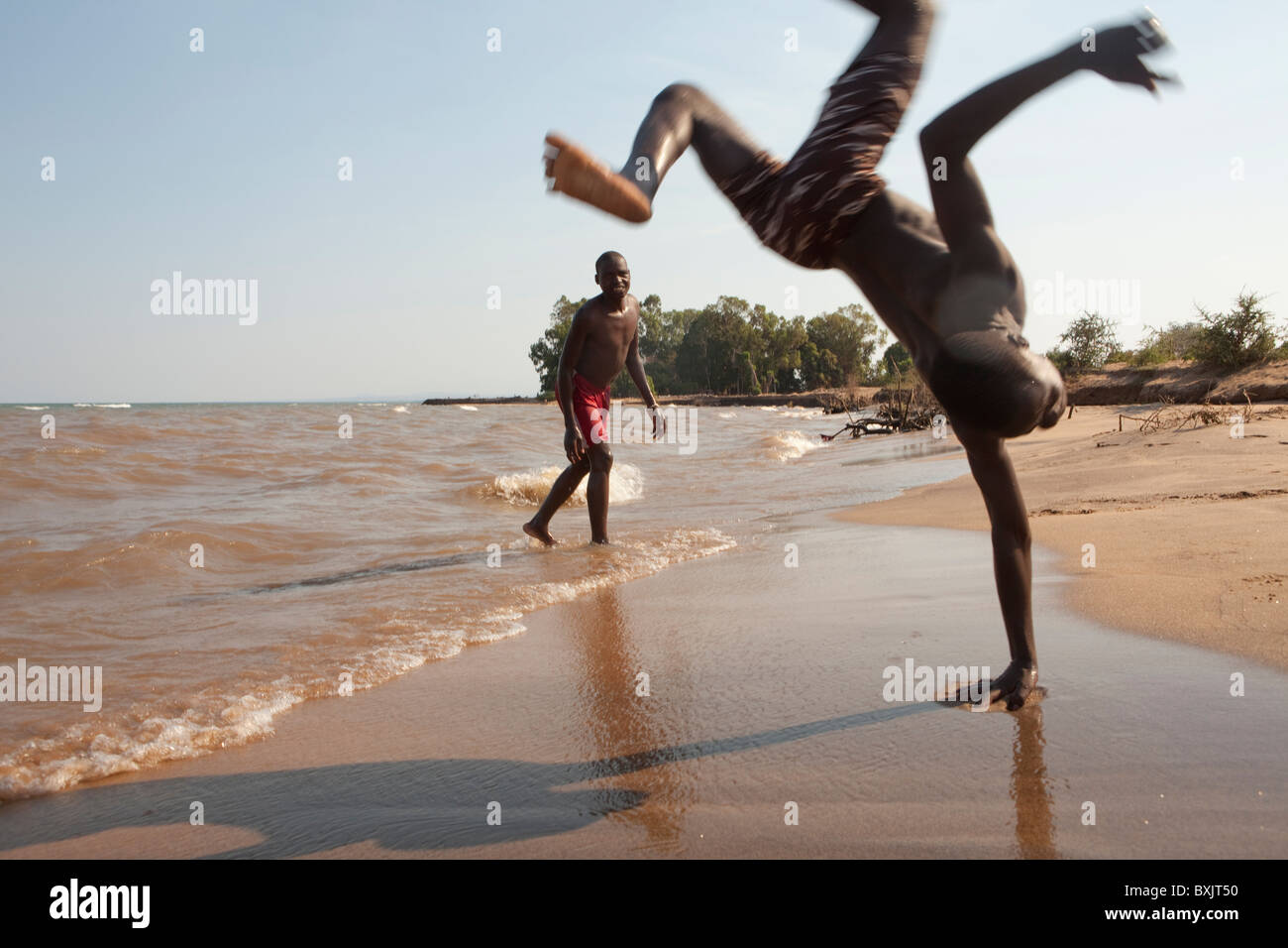 Youths exercise on the shores of Lake Malawi near the town of Karonga, Malawi in Southern Africa. Stock Photo