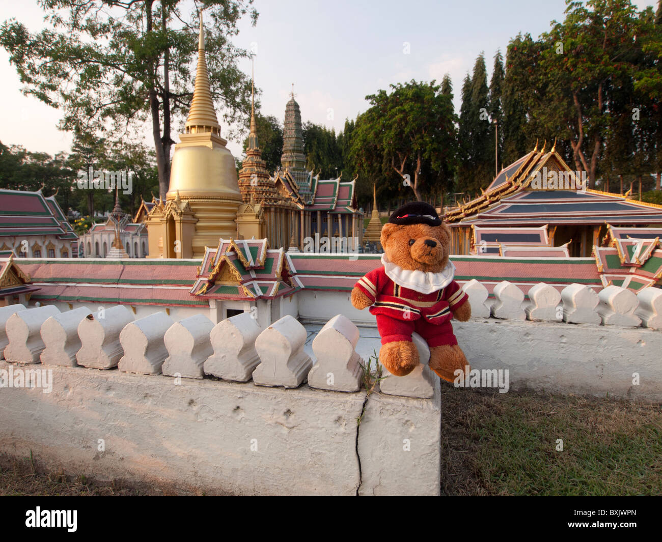 Harrods Teddy Bear sitting on the fence of Wat Phra Kaew at Mini Siam Pattaya, Thailand Stock Photo