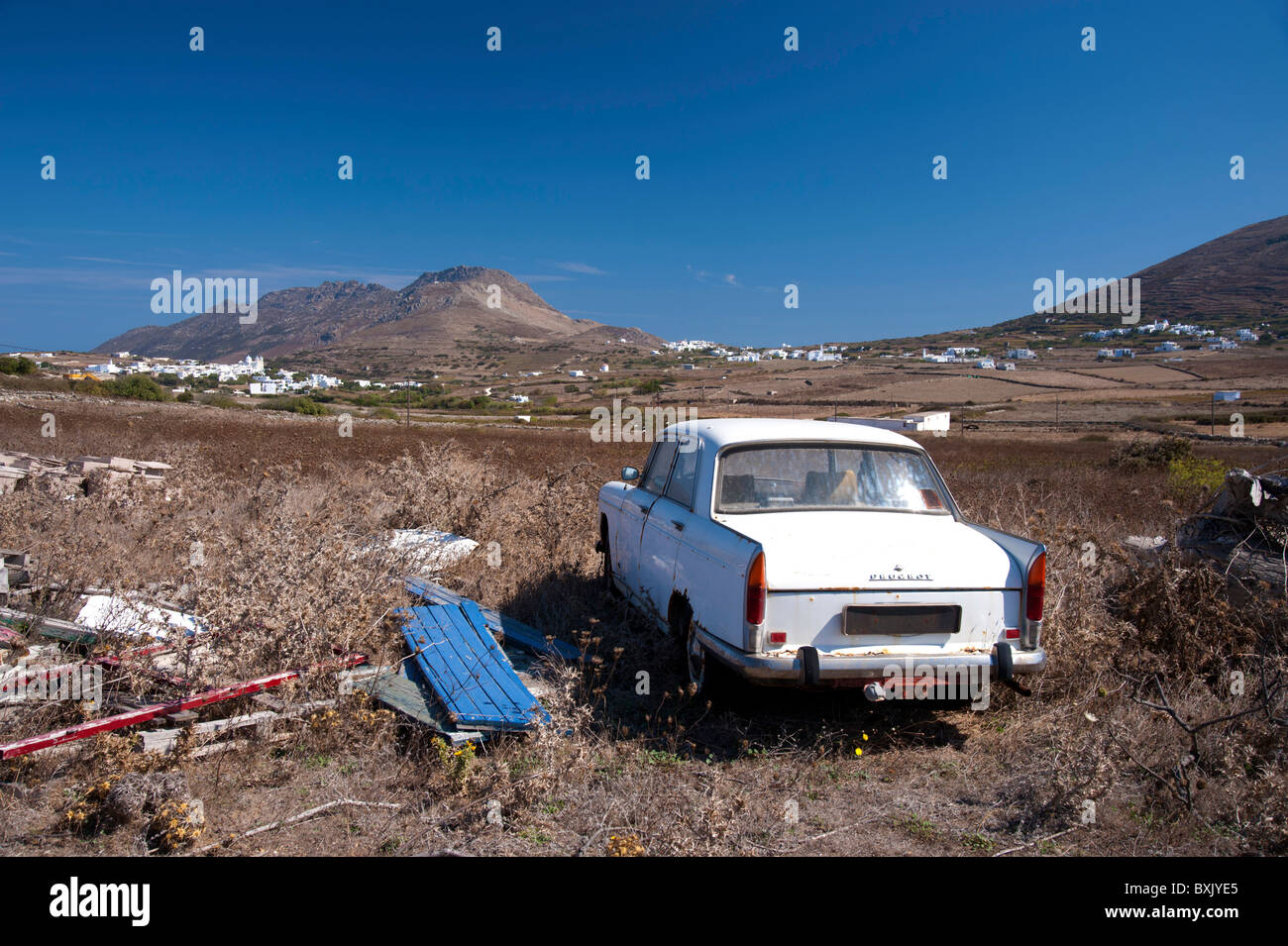 Old Peugeot car abandoned in a field in the countryside of the Greek Cyclade island of Tinos. Stock Photo