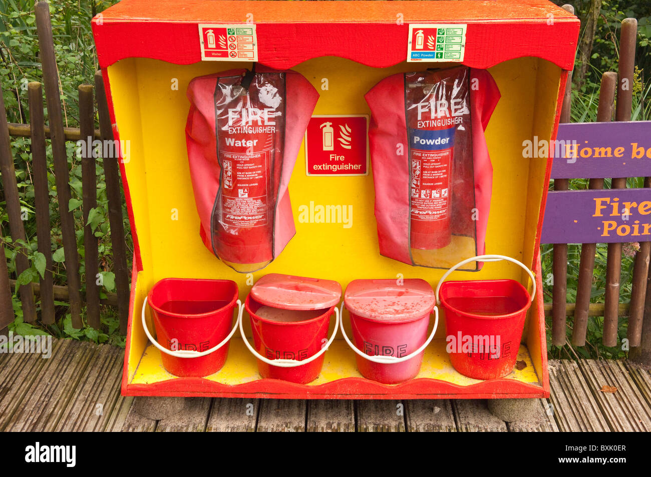 Fire extinguishers and water and sand buckets at Bewilderwood adventure park in Hoveton , Norfolk , England , Great Britain , Uk Stock Photo
