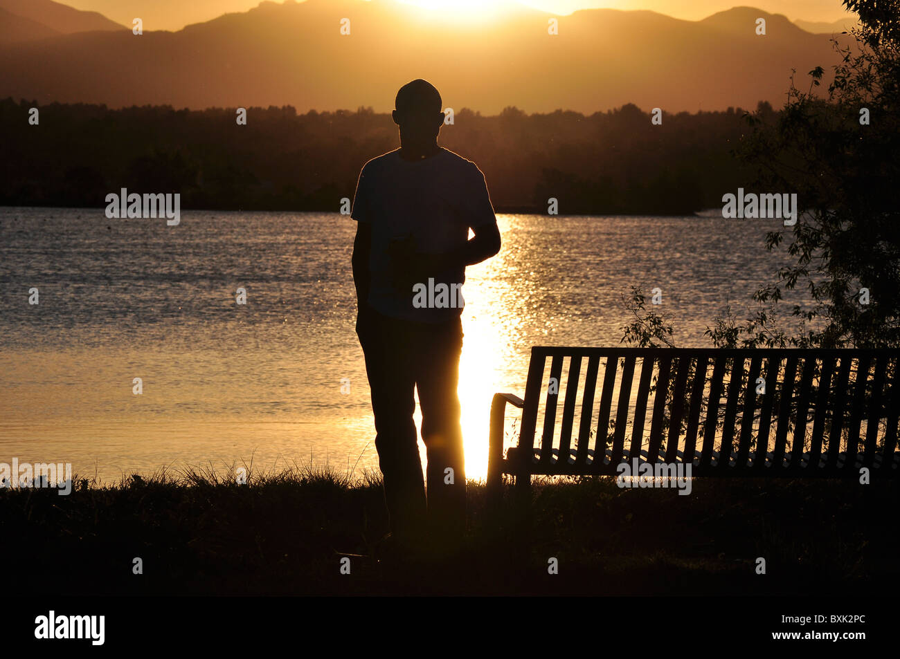 silhouette man lake water reflection sunset Stock Photo