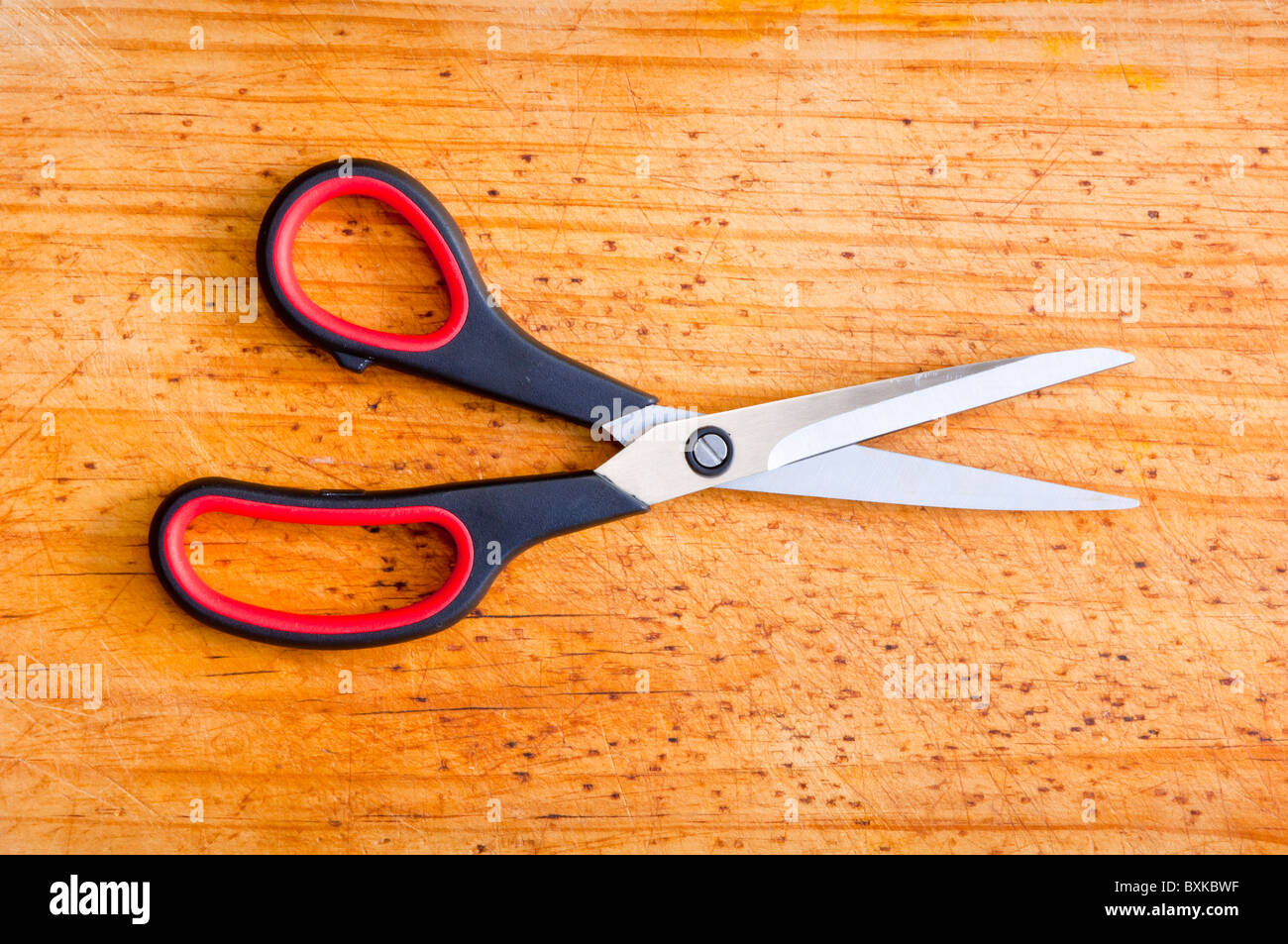 Modern scissors sit atop a wooden board Stock Photo Alamy