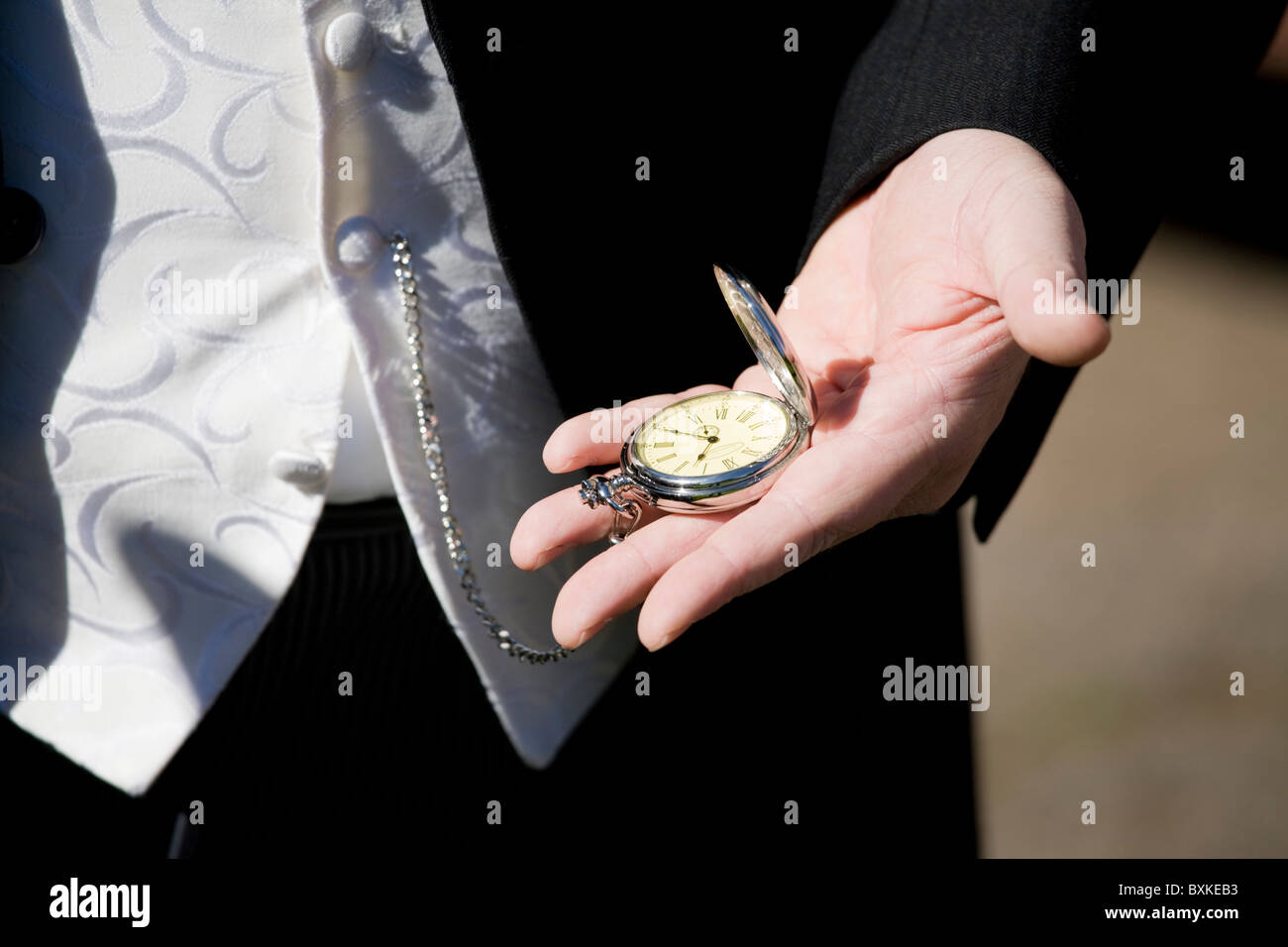 Groom with pocket watch waiting for the bride to arrive Stock Photo