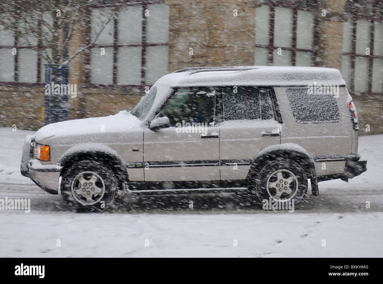 Land Rover four-wheel drive vehicle in heavy snowfall,  Warwick town centre, UK Stock Photo