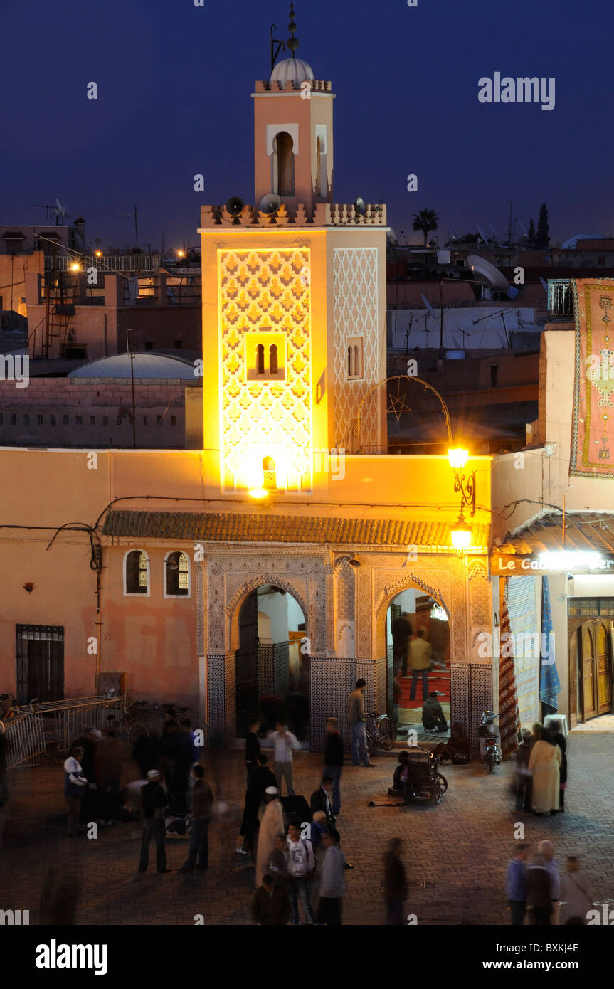 Mosque & Djemaa el-Fna street scene at night in Marrakech Stock Photo