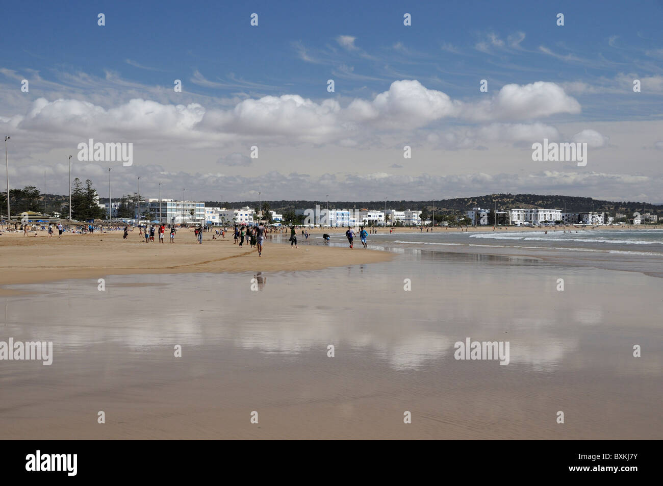 Beach scene with cloud reflections on sand Stock Photo
