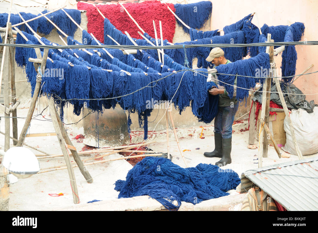 Dyer hanging dyed wools to dry at Souk Teinturiers in Marrakech Stock Photo