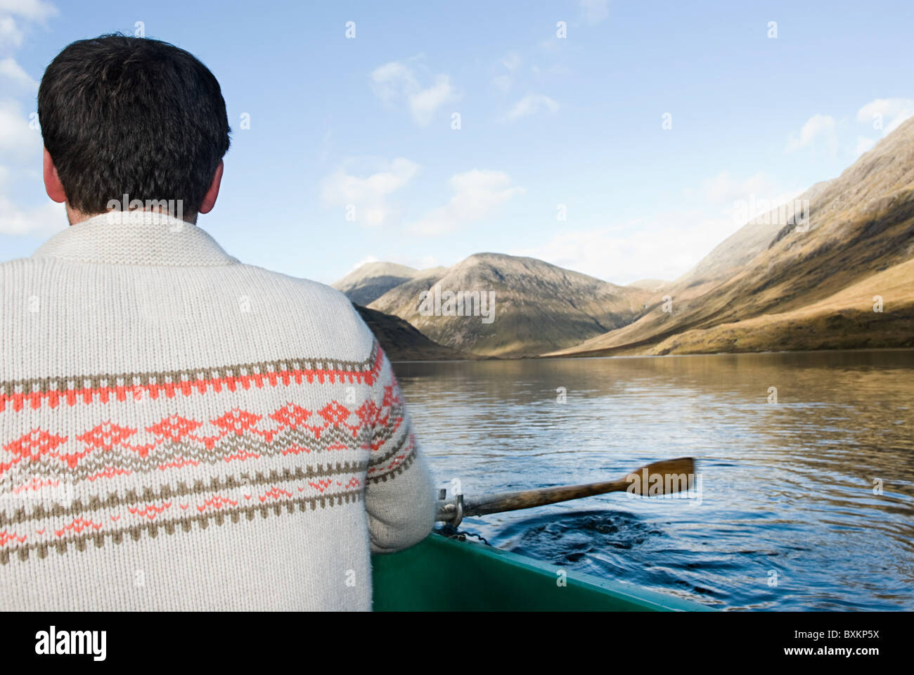 Man in rowing boat on lake Stock Photo