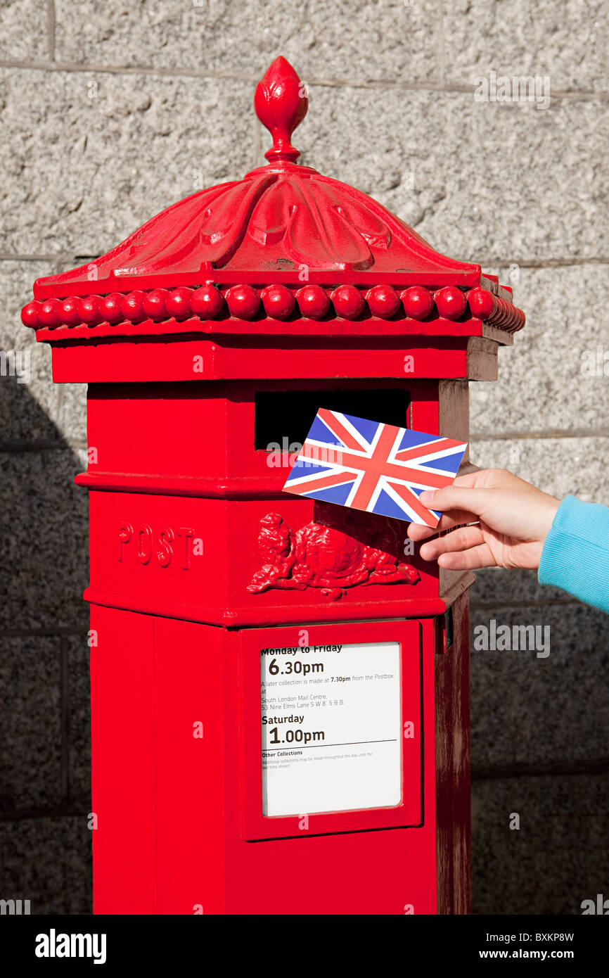 Person putting postcard in post box, London Stock Photo - Alamy