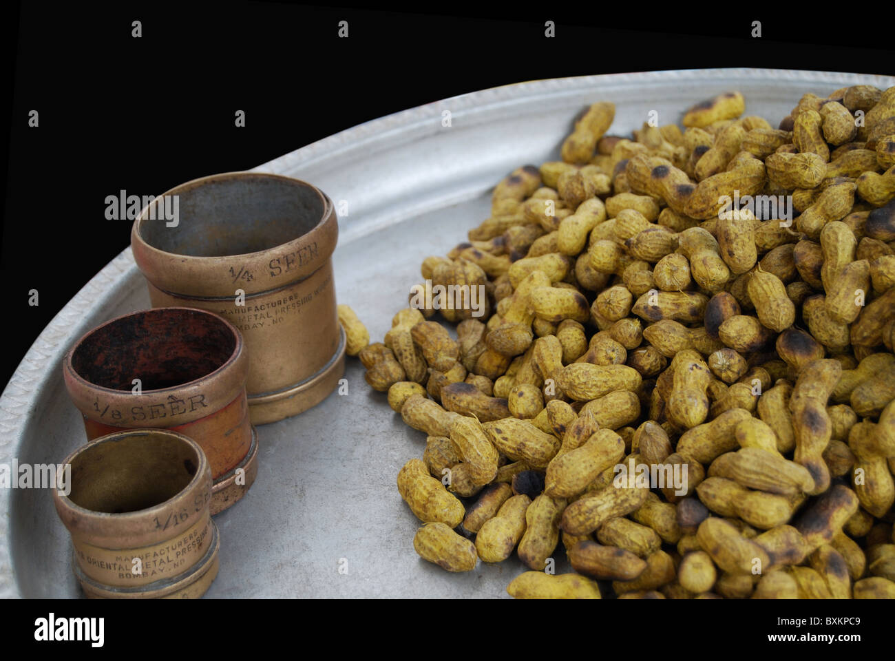Boiled groundnuts for sale in the market , Satara. Old traditional measurements are also seen along with. Stock Photo