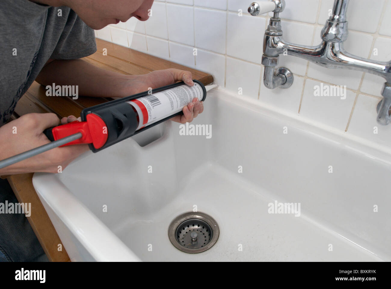 Man using sealant gun in bathroom Stock Photo Alamy