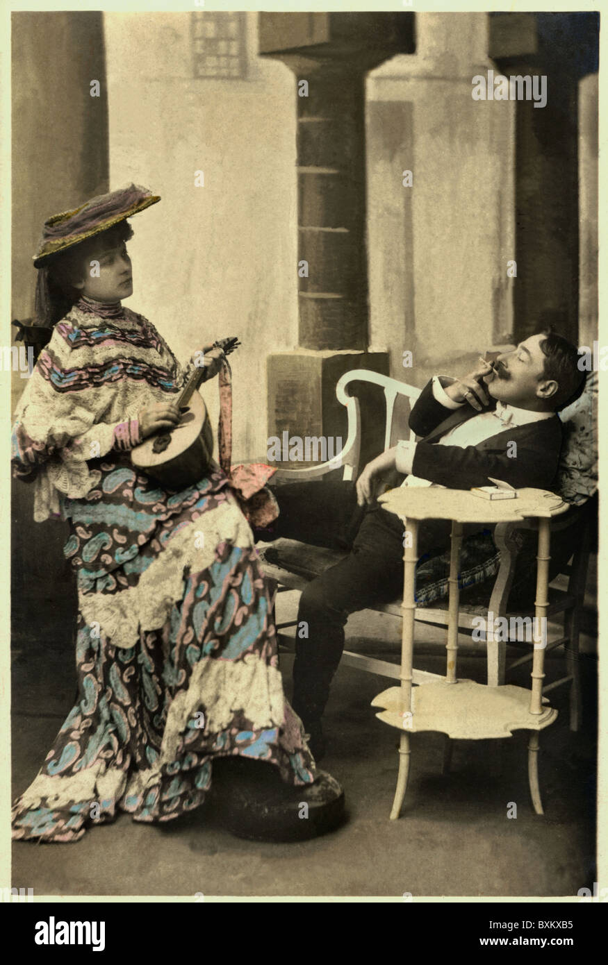 tobacco / smoking, cigarettes, man smoking and relaxing on a bench while his wife is playing a mandolin, Portugal, 1907, Additional-Rights-Clearences-Not Available Stock Photo