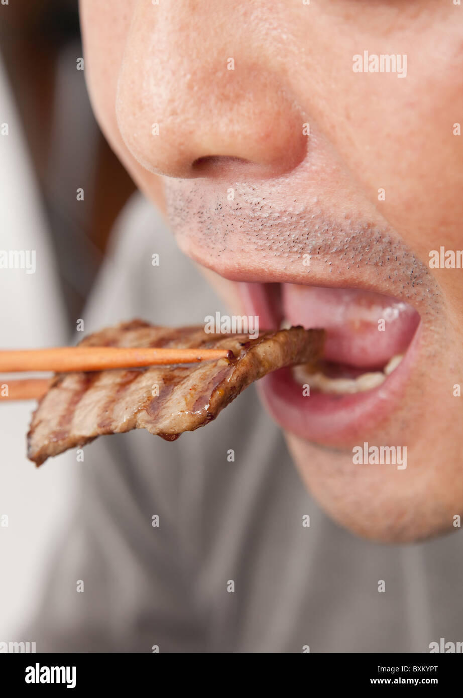 A man eating korean barbecue Stock Photo