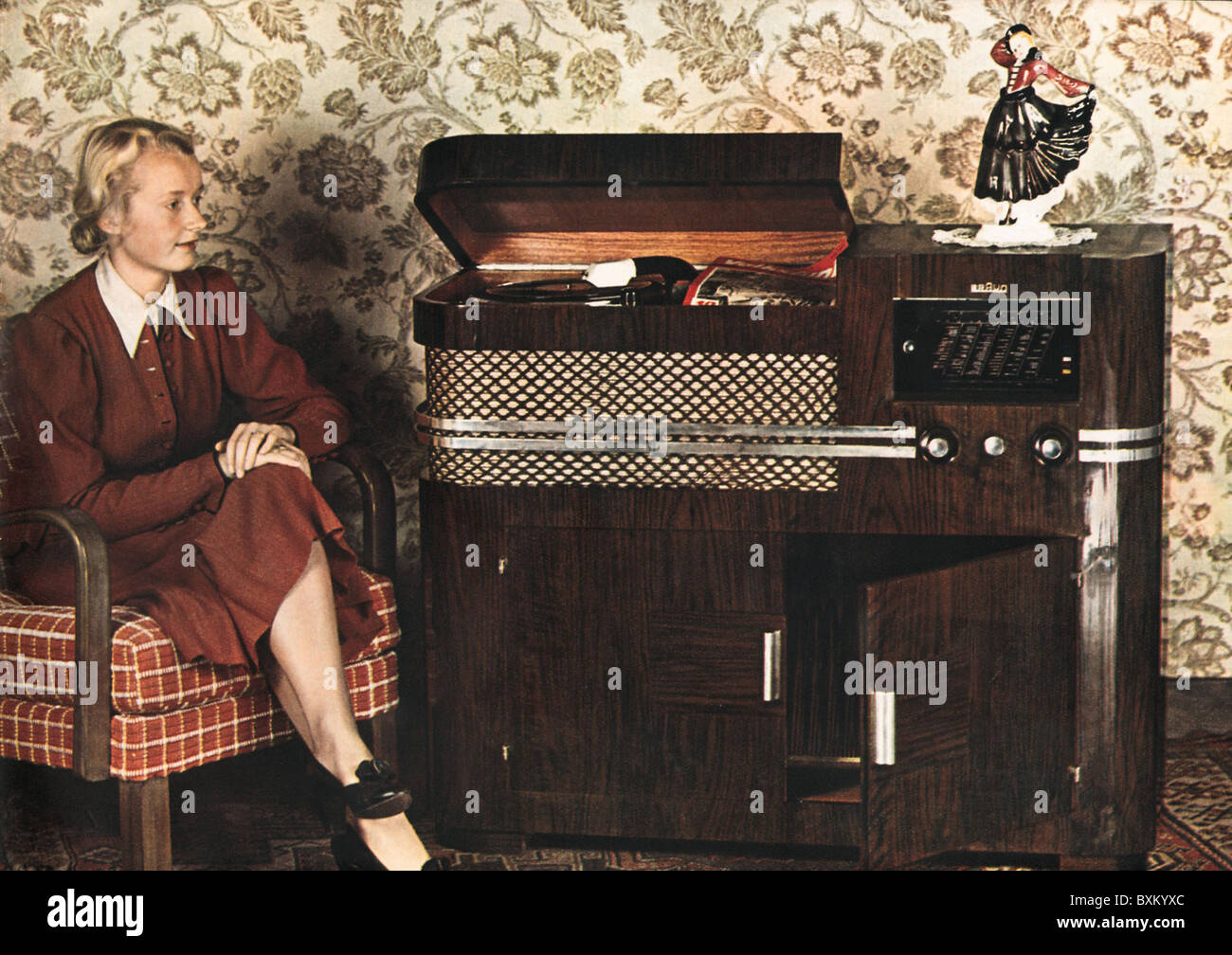broadcast, radio, woman with Braun music chest 739, Germany, 1939, 1930s, 30s, 20th century, historic, historical, record player, record players, combined, radio set, radio, radio sets, radios, home electronics, consumer electronics, entertainment electronics, home entertainment, furniture, sitting, audio, phono, sound, listener, listeners, cabinet, people, nostalgia, women, female, Additional-Rights-Clearences-Not Available Stock Photo