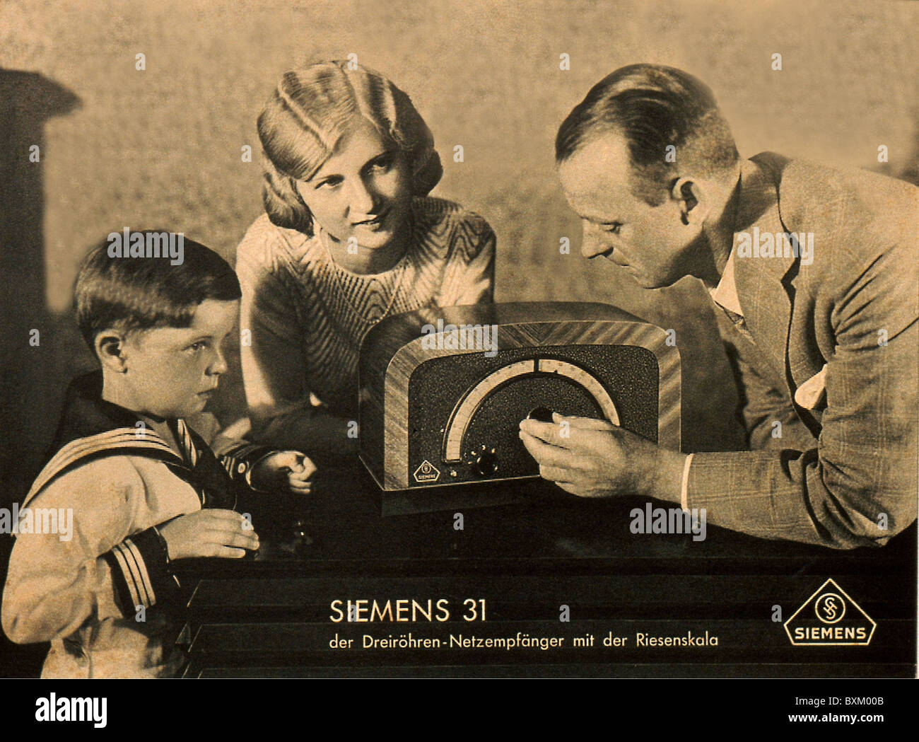 broadcast, radio, family is listening to the radio, Siemens radio type 31, advertising, Germany, 1930, 1930s, 30s, 20th century, historic, historical, listener, listeners, parent, parents, son, sons, sailor suit, media consumption, home electronics, consumer electronics, entertainment electronics, home entertainment, people, nostalgia, Additional-Rights-Clearences-Not Available Stock Photo