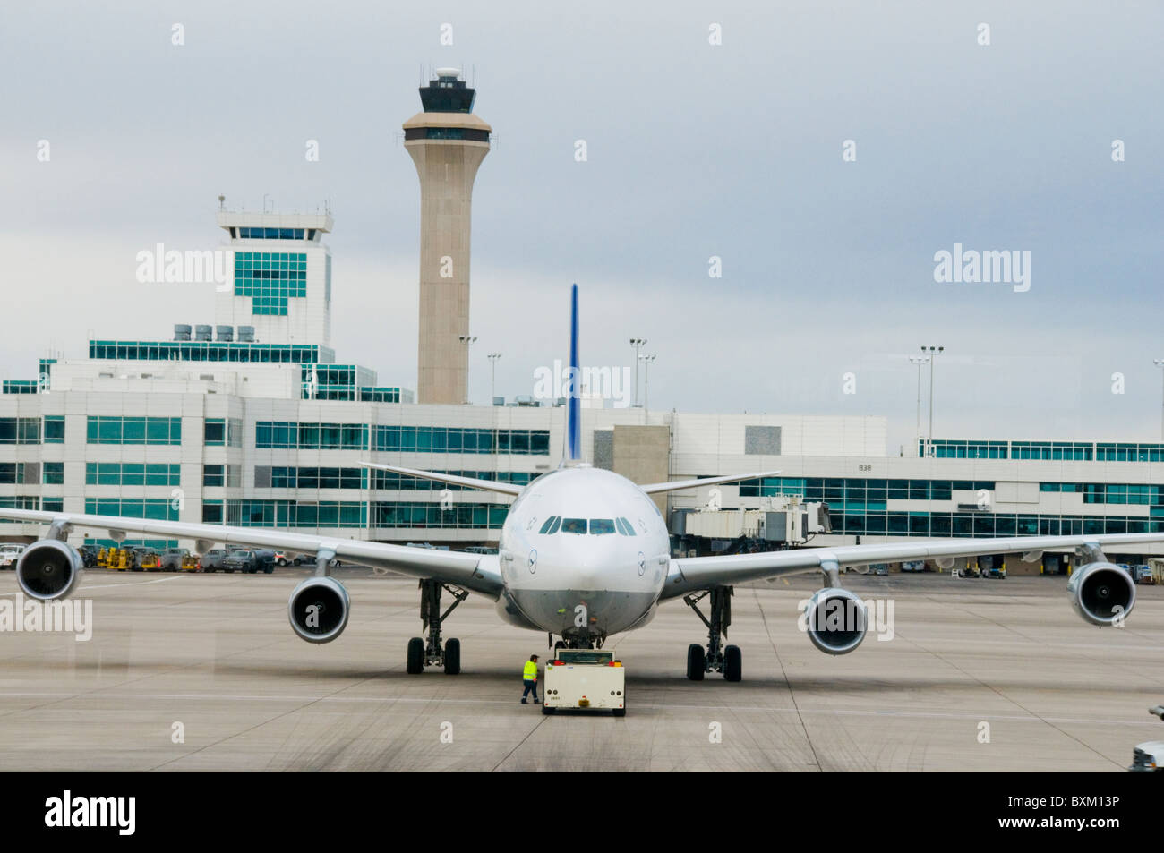 Airplane at airport gate sitting on tarmac being fueled and serviced for departure Stock Photo