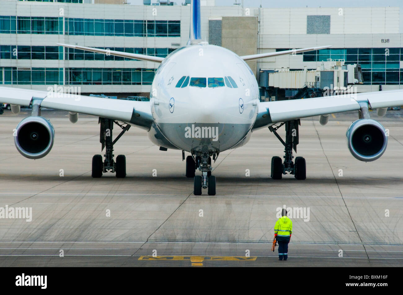 Airplane at airport gate sitting on tarmac being fueled and serviced for departure Stock Photo
