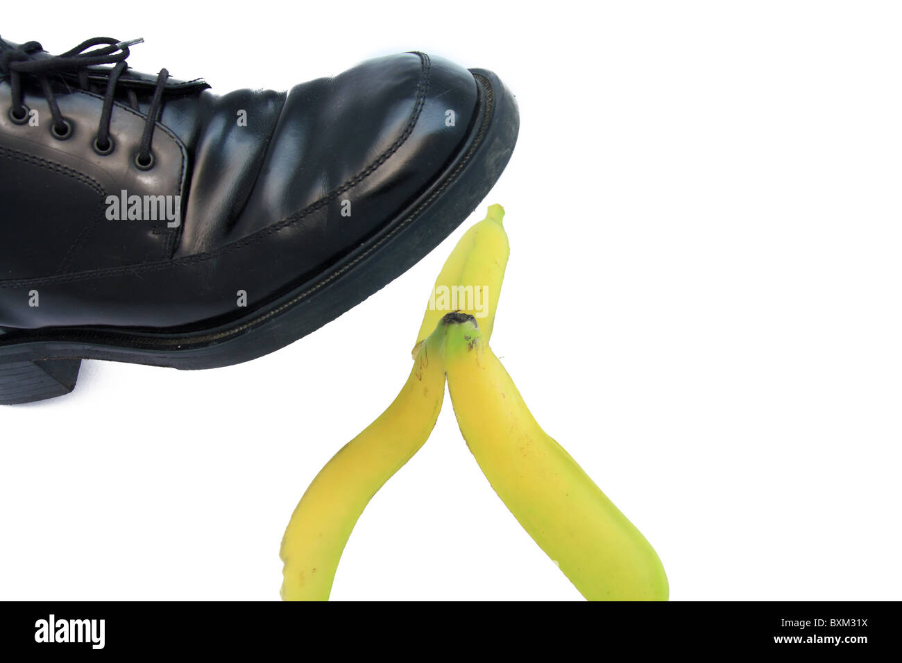Business boot to step on a banana skin on a white Stock Photo