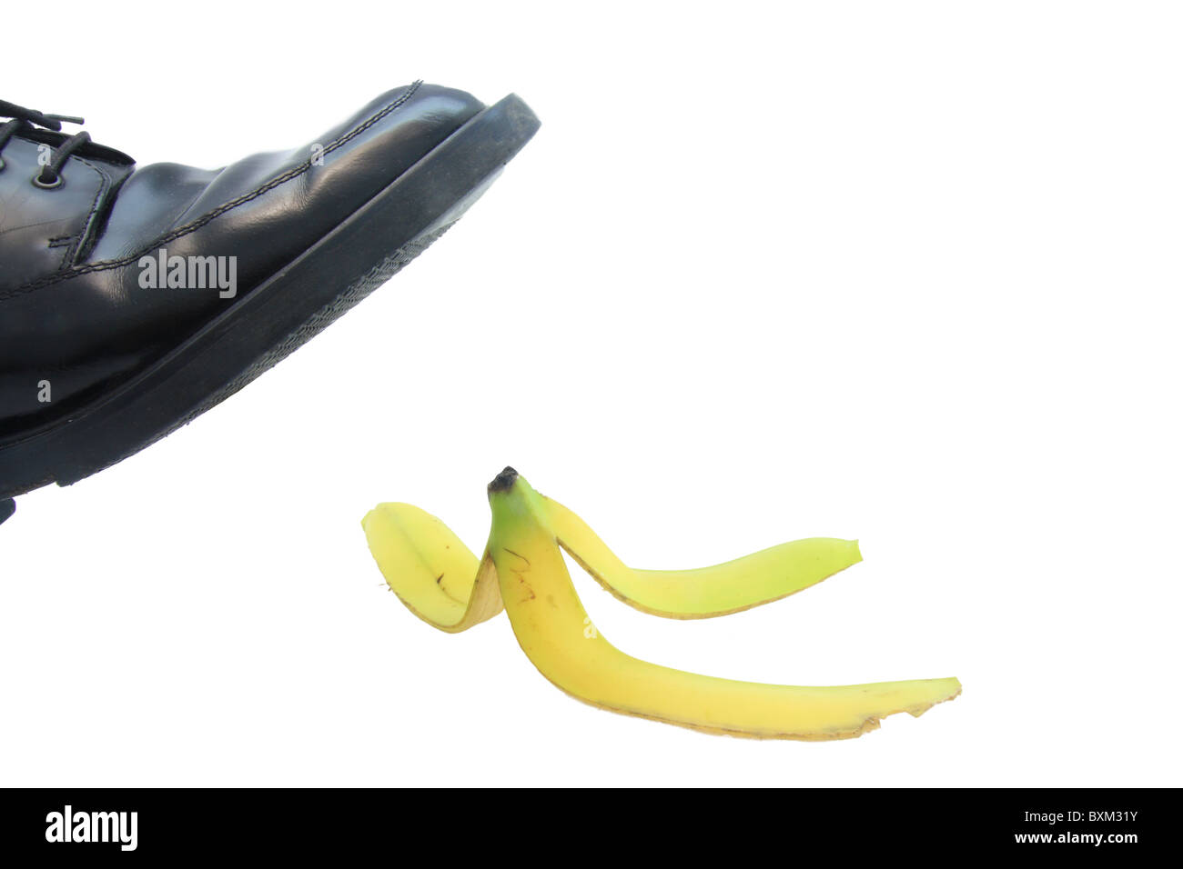 Business boot to step on a banana skin on a white Stock Photo