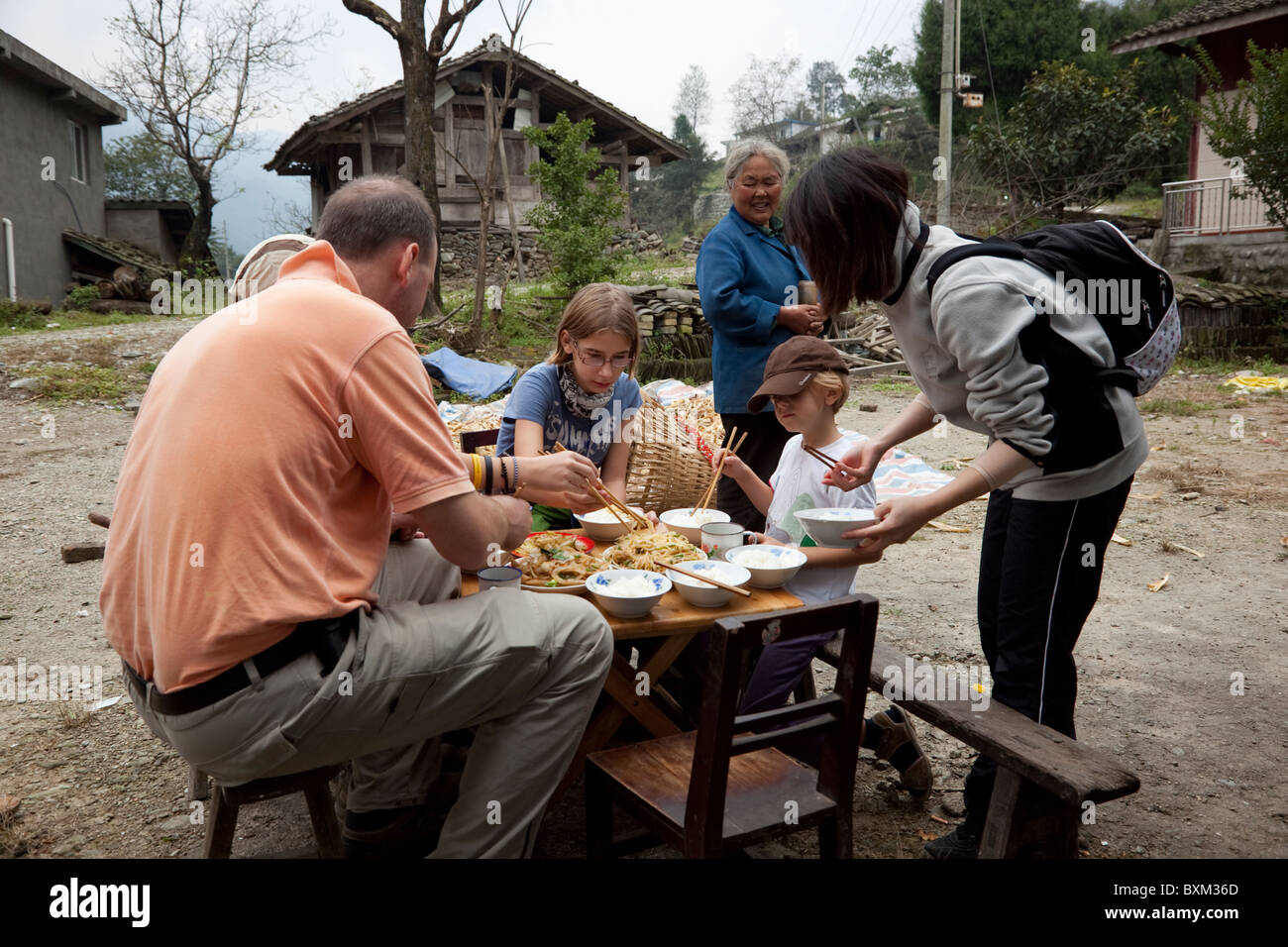 A group of trekkers having lunch prepared in a small isolated village in west China. Stock Photo