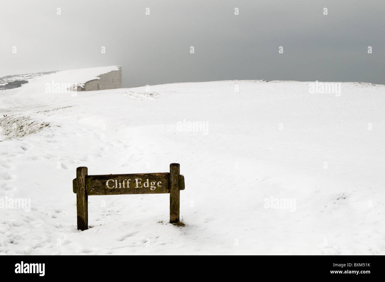 Cliff Edge sign in the snow with poor visibility Stock Photo