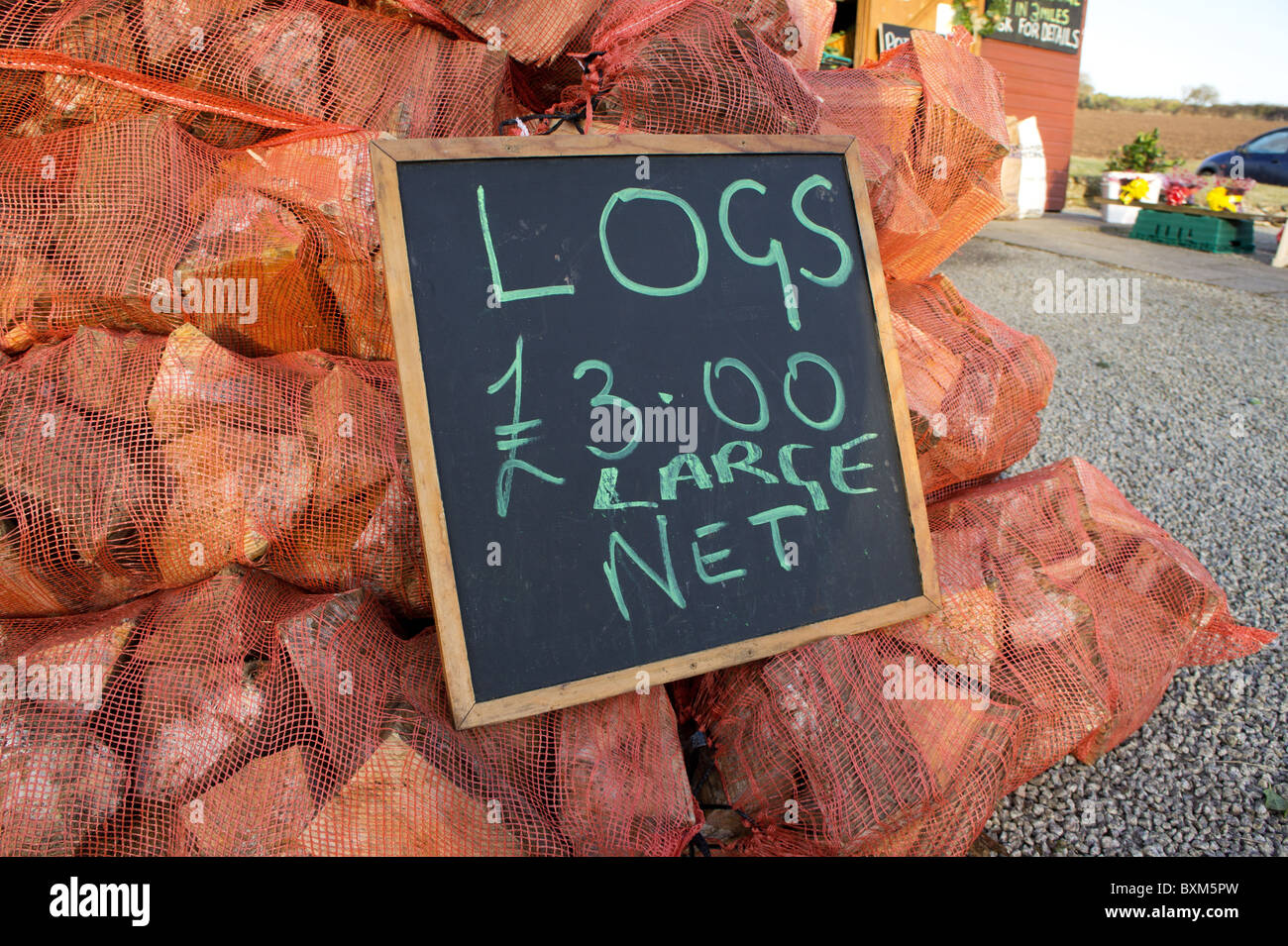 bags of logs for sale at a roadside farm shop, cornwall, uk Stock Photo