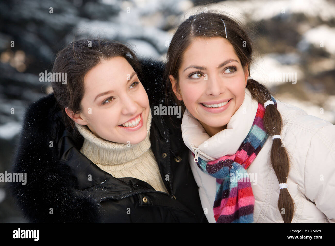 Two smiling girls having fun in the winter forest Stock Photo - Alamy