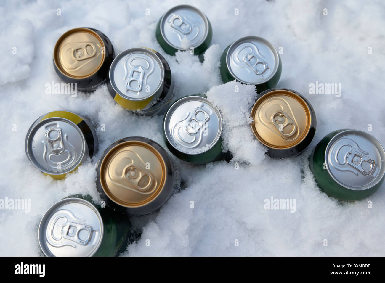 beer and alcohol cans buried in snow to keep them cool outdoors during winter Stock Photo