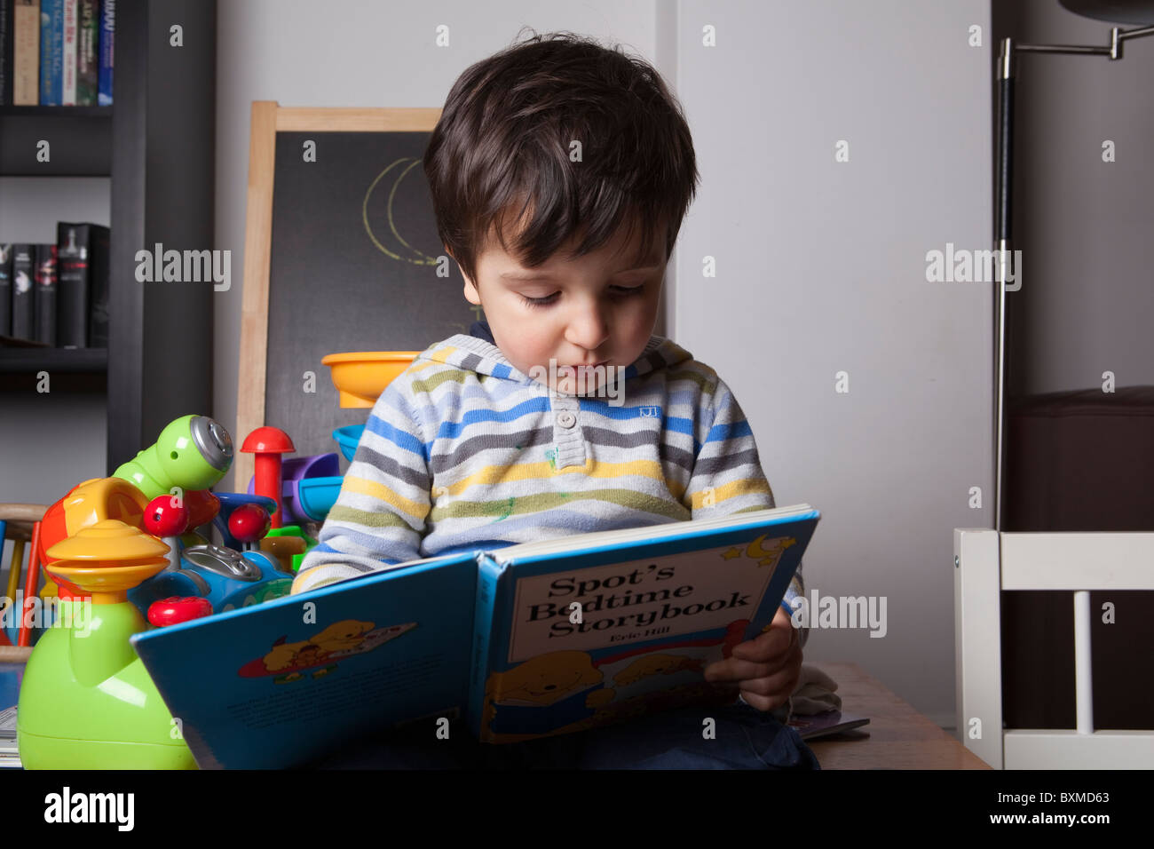 toddler reading bedtime story alone Stock Photo