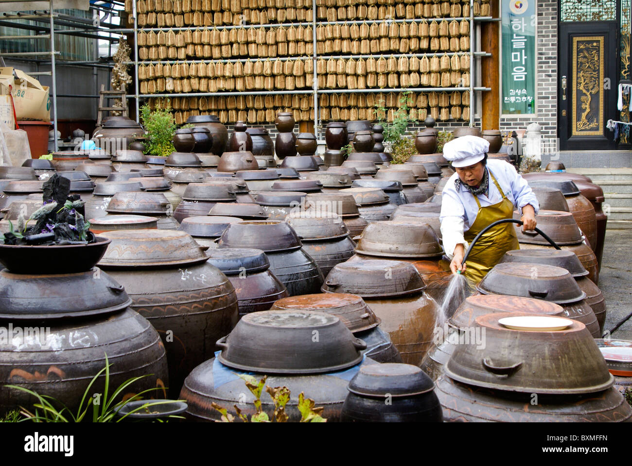 Dried bean paste (hanging) and clay jars containing jangachi, Sunchang Traditional Gochujang Village, South Korea Stock Photo