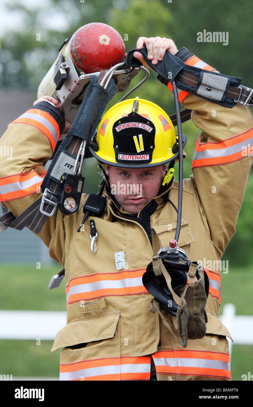 A fire fighter putting on the oxygen tank gear firefighter firefighting