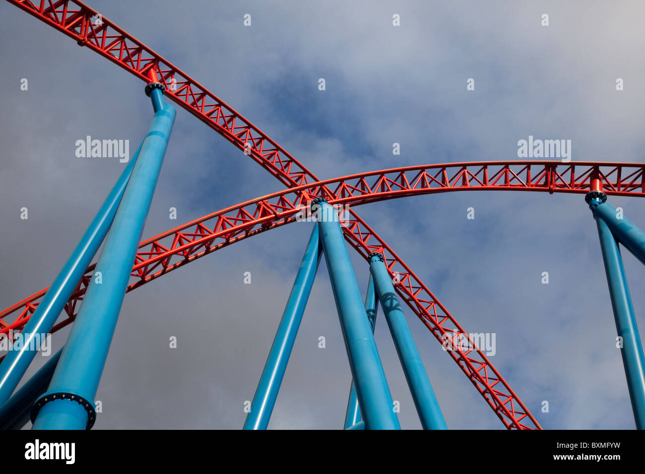 two red roller coaster tracks crossing to form an x Stock Photo