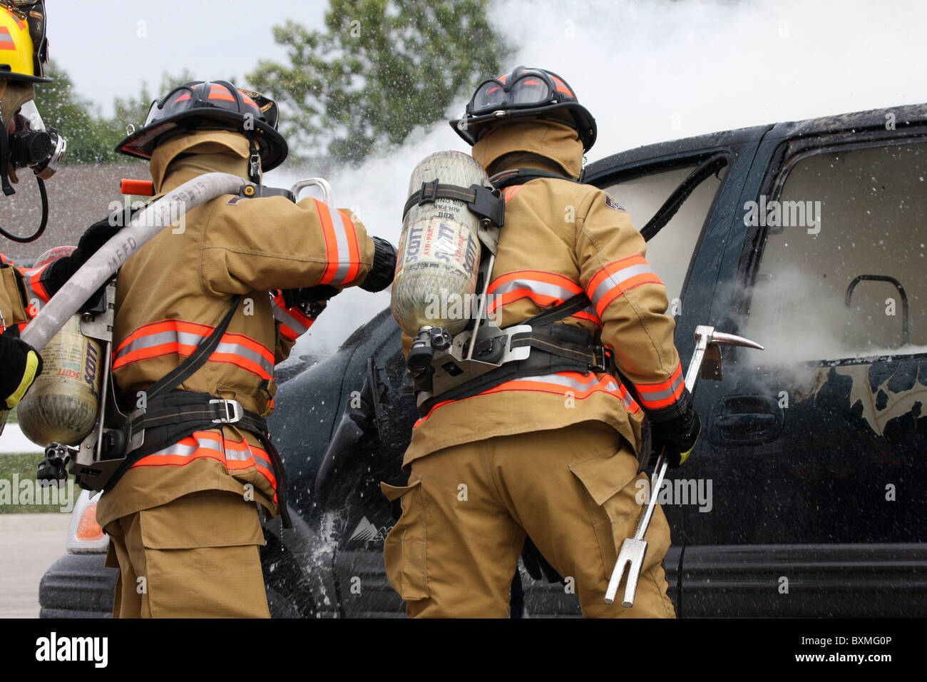 Firefighters on a hoseline fighting a car fire Stock Photo Alamy