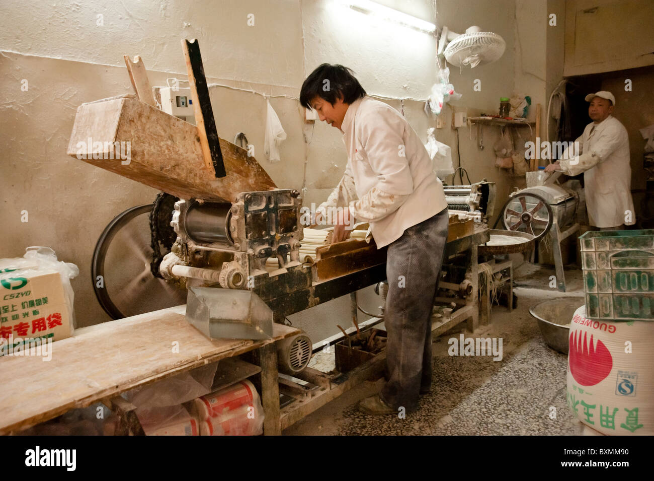Unidentified man working in a factory using a machinery to make noodles in Chongqing, Dec 21, 2010. Stock Photo