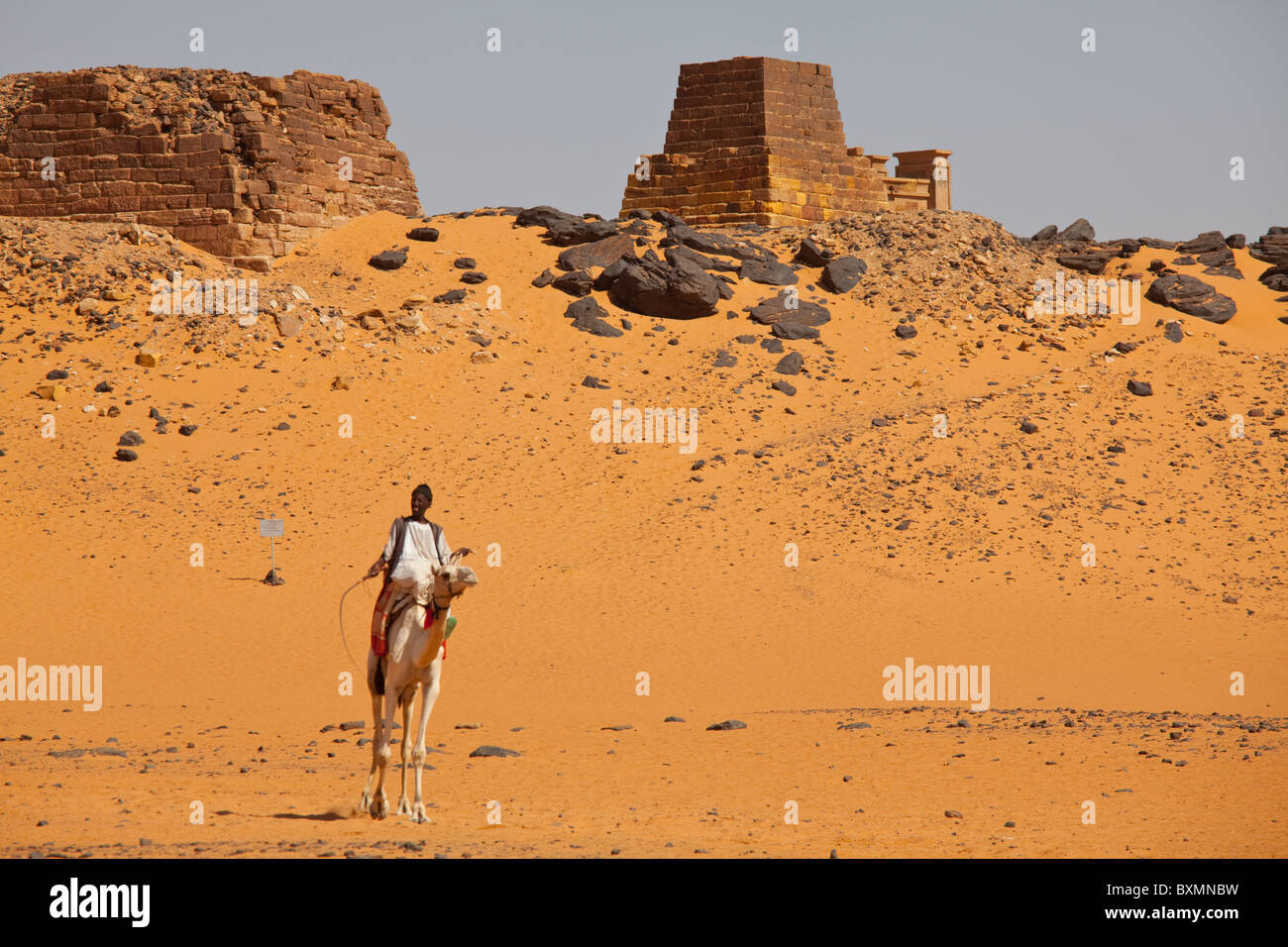 Boy on camel near Pyramids in Nubian pharaohs and kings necropolis in Meroe ,Nubia, Sudan Stock Photo