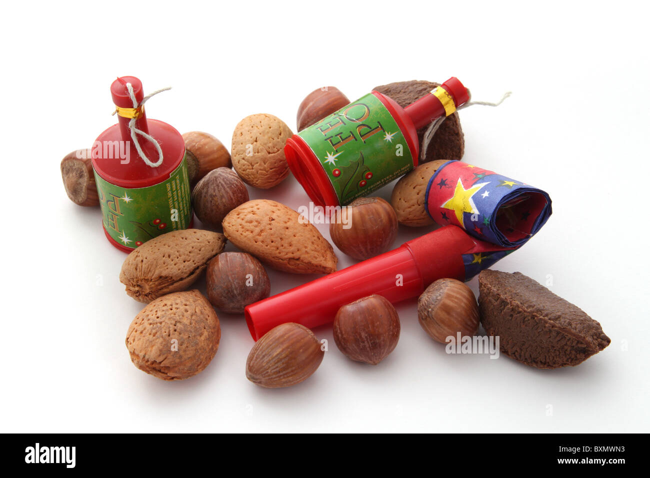 Mixed nuts with party blowers and poppers on a plain white background ...