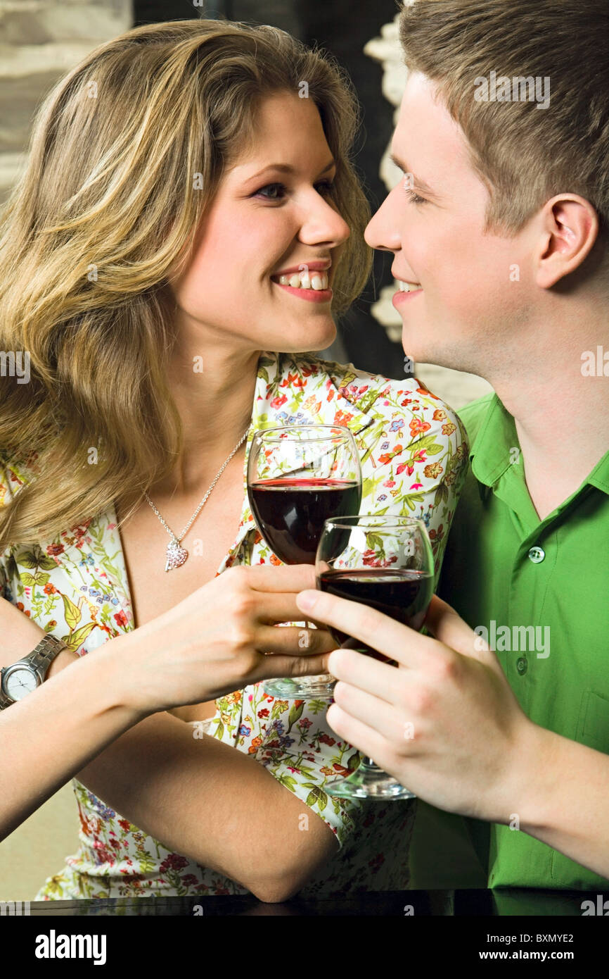 Young couple is holding the glasses of red wine in a restaurant Stock ...