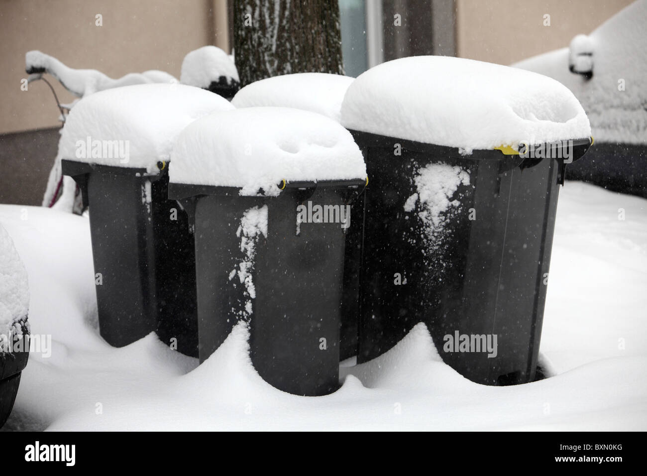 Snow covered garbage bins, full, waiting for rubbish collection Stock