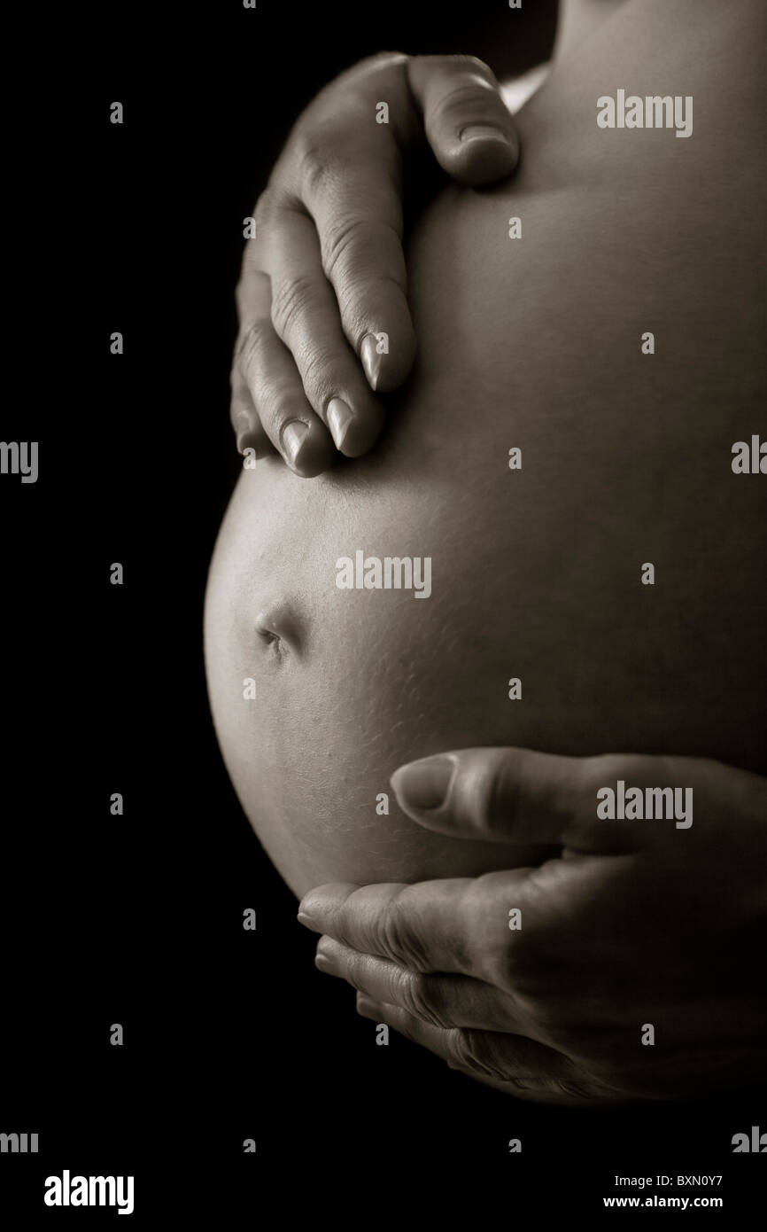 Pregnant woman holding her belly Stock Photo - Alamy