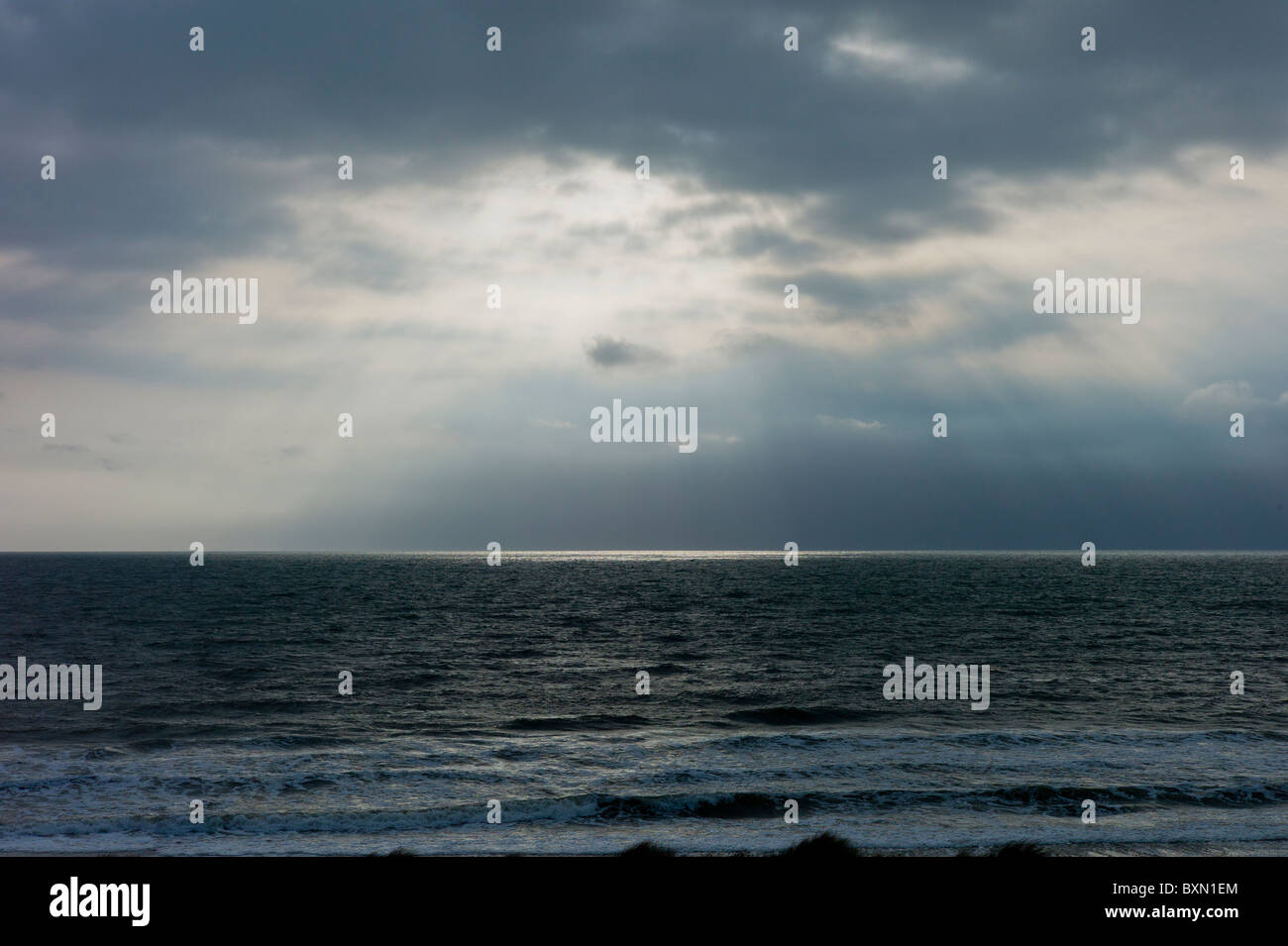 Sun's rays over rough sea at dawn on a windy day at Rosslare, South ...