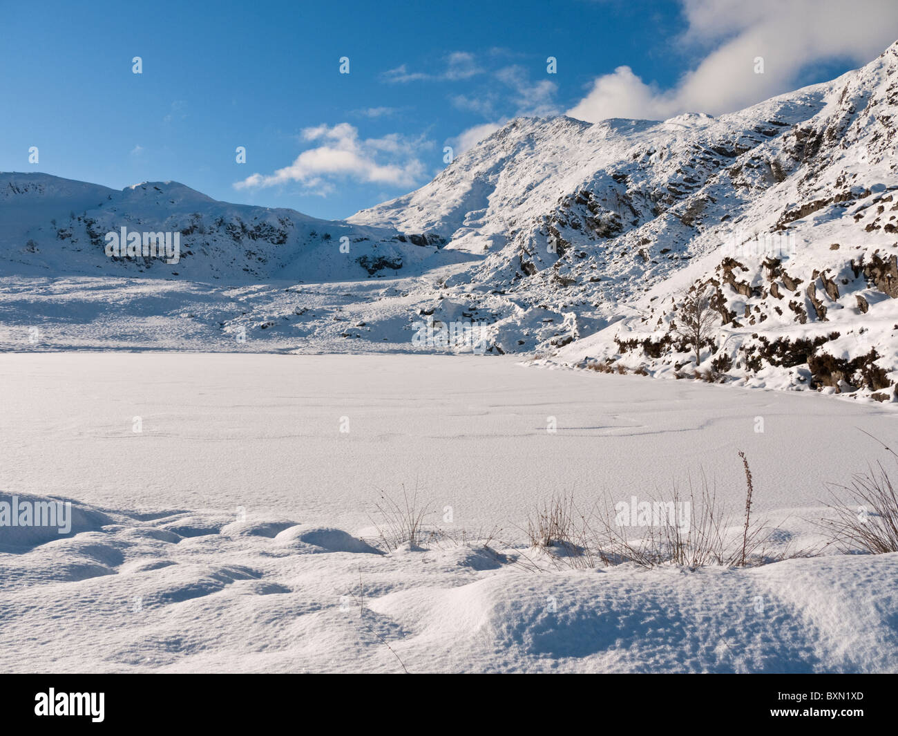 Winter snow on a frozen lake, part way up Moel Siabod in Snowdonia Stock Photo