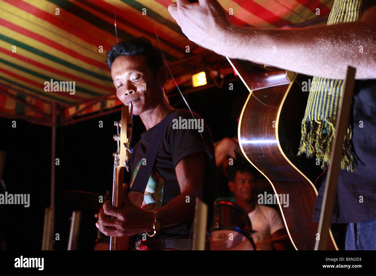A Khmer bass player performs in Kampot, Cambodia Stock Photo