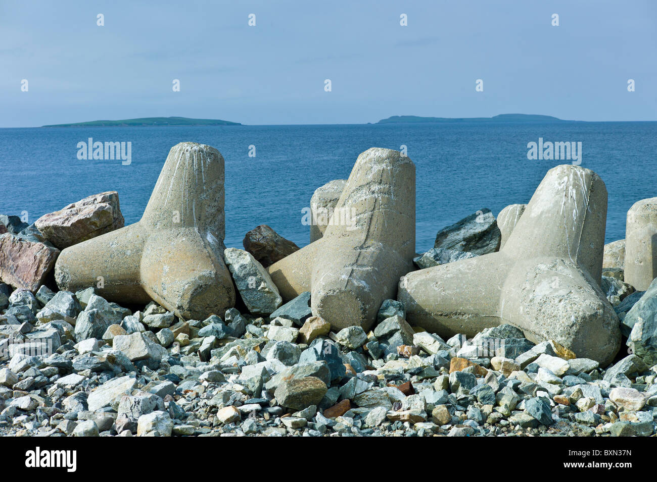 Saltee Islands in Irish Sea with sea defences in foreground, Kilmore, County Wexford, Ireland Stock Photo