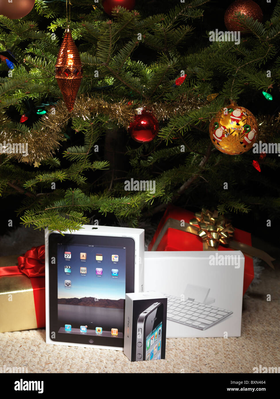 Apple iPad and iPhone 4 amongst presents under a Christmas tree Stock Photo
