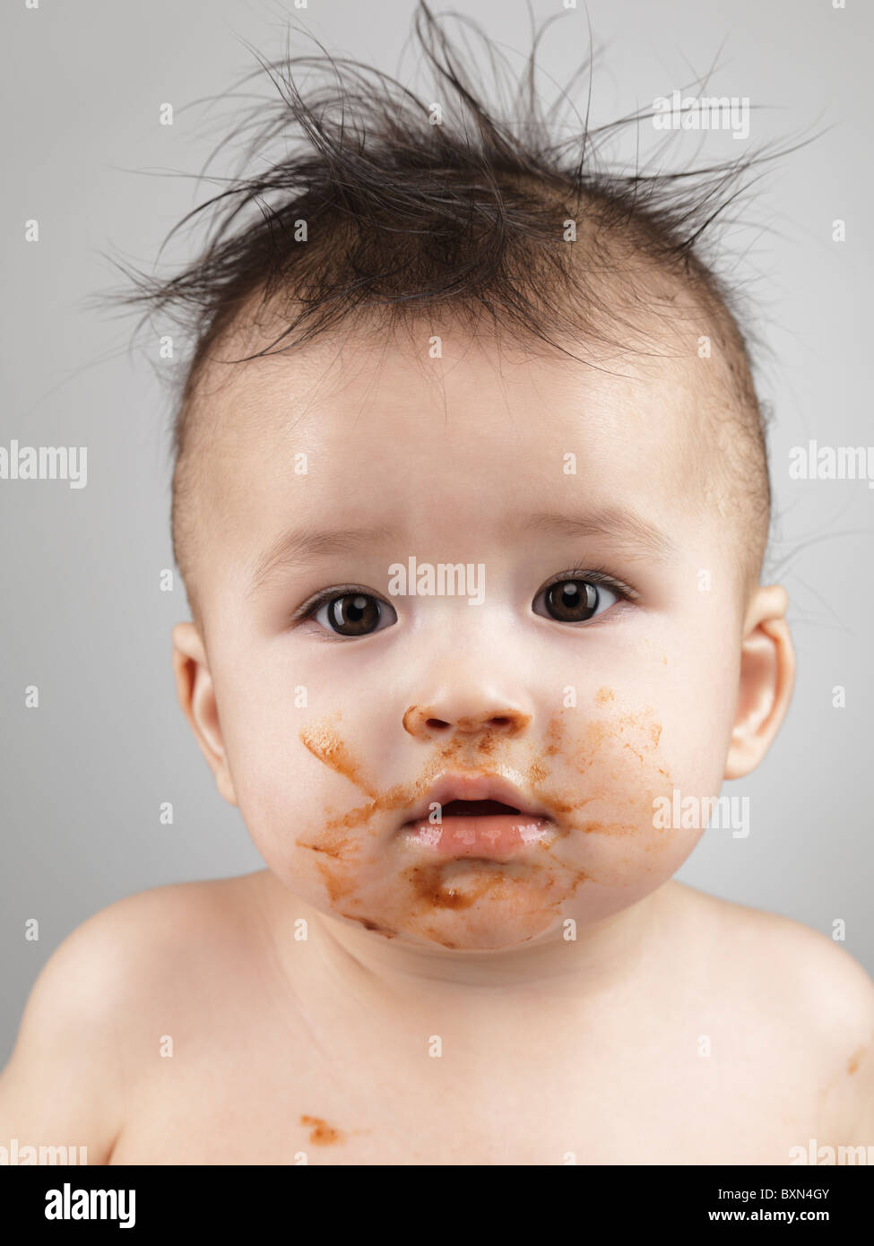 License available at MaximImages.com - Artistic portrait of a seven month old baby boy with messy hair and smudged with food face Stock Photo